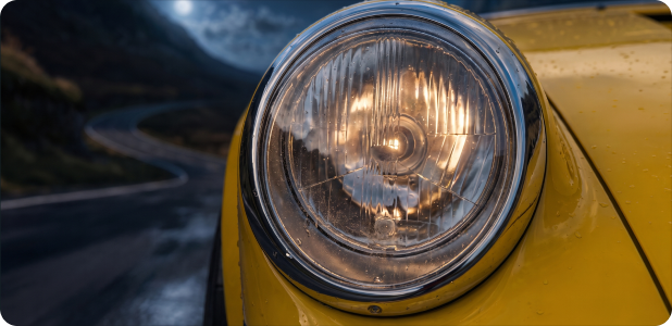 Porsche 911 R-Spec headlights illuminating wet mountain pass at night